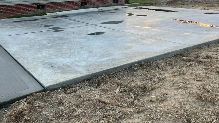 Fresh concrete slab laid out for building foundation with pooled water from rain