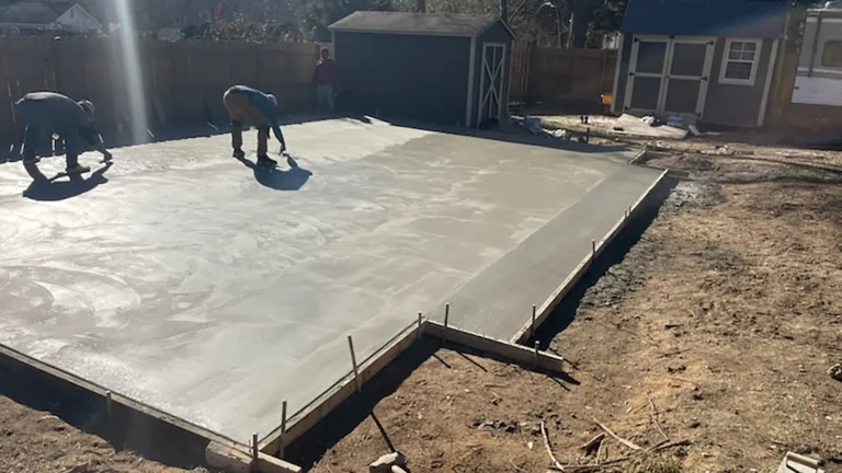 Construction workers preparing concrete slab surface