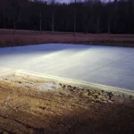 New concrete slab foundation setting on construction site at night